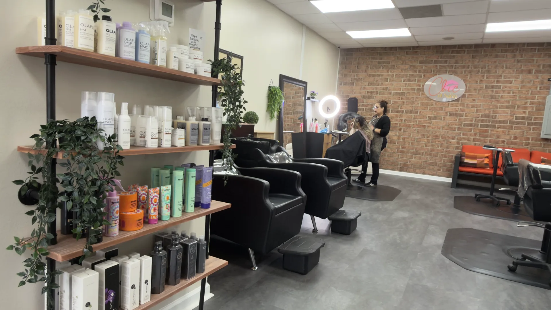 Retail product shelves and a stylist working with a client at Chic El Salon in Charlotte, NC